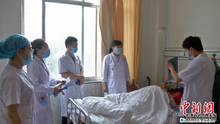 天津医生李汶泽(右二)在病房为患者指导诊断病情，同时为年轻医生传授相关经验。　李文 摄